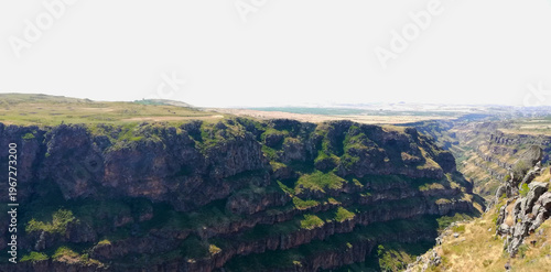 Фотография Rugged Rock Cliff Face with Green Vegetation, view from the top of the mountain