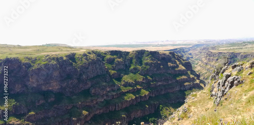 Fotografie Rugged Rock Cliff Face with Green Vegetation, view from the top of the mountain