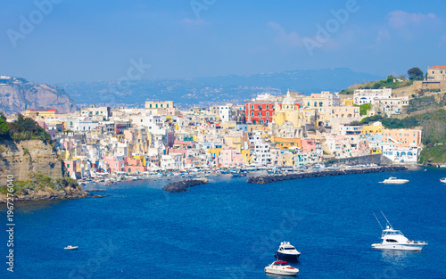 Colorful houses, cafes and restaurants, yachts and fishing boats in Marina Corricella, Procida Island, Italy. Picturesque Procida in sunny day