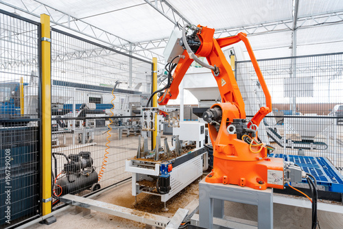 Obraz na plátně Orange industrial robotic arm operating on an automated production line in a fac
