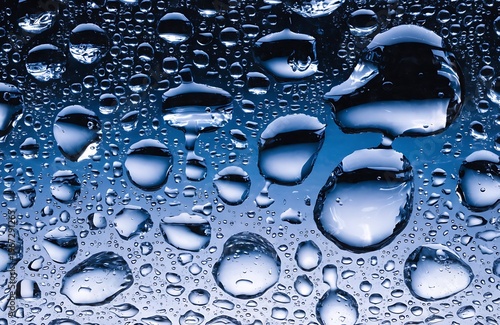Water droplets on blue gradient glass surface texture background high resolution photo
