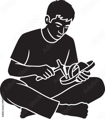 Black silhouette of a man sitting crosslegged whittling wood