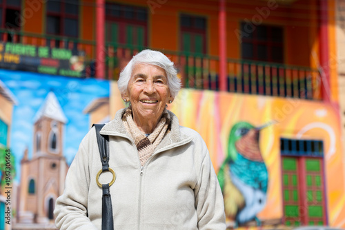 Happy senior lifestyle concept. Senior woman at the central square of the beautiful small town of Raquira. The city of pots in Colombia.