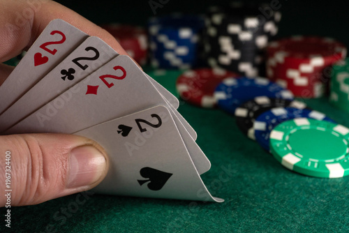 Фотография A person holds four of a kind or quads in a poker game while sitting at a casino table