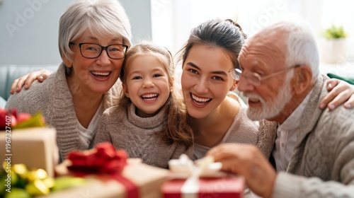 Family Gathers Around Gifts During Holiday Celebration in Warm Living Room Wi...
