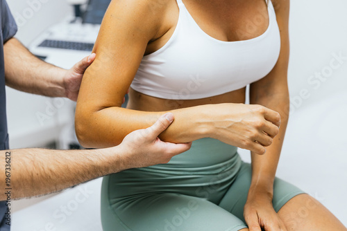 Physiotherapist examining woman's elbow joint mobility