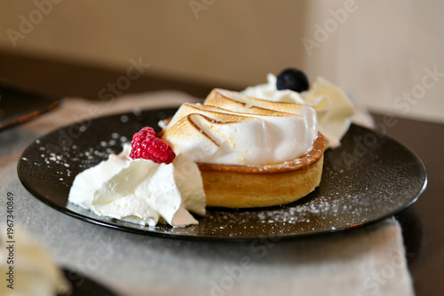 French tarte au citron with meringue and berries dessert plate