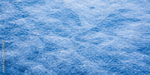 A frosty blue ice texture and winter snow pattern create an abstract frozen surface with crystal light and white nature backgrounds for a cold Christmas season