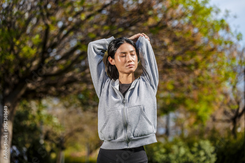 Young woman stretches in a park in Spain during daylight hours