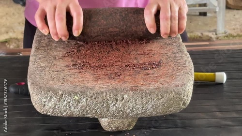 Closeup of Grinding Roasted and Dried Cacao Beans With a Stone to Make Chocolate
