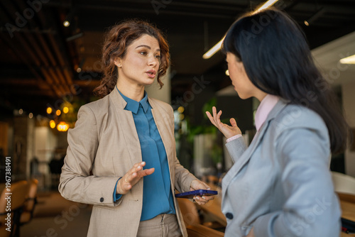 Photos Businesswomen talking collaborating and discussing ideas in office