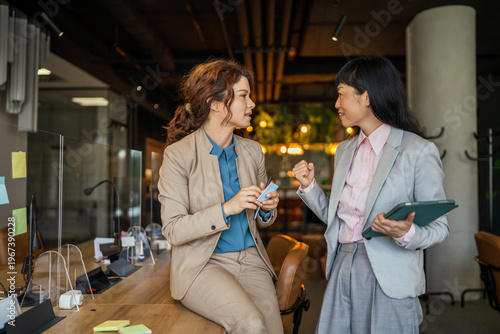 Business women collaborating and discussing work in modern office