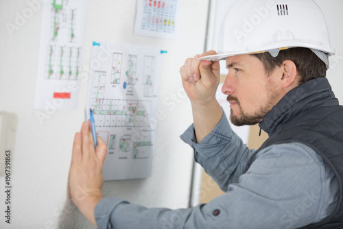 Canvas Print surprised worker reads construction plans