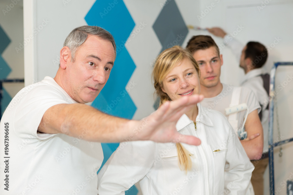 Fototapeta premium decorator talking to group of apprentice students