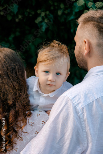 Konstfotografi A young boy with blue eyes is held between his parents