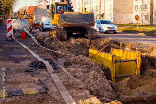 Foto Excavator digging trench for underground utility repair on city street