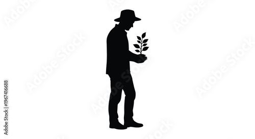 Man carefully tending to a small plant a striking silhouette