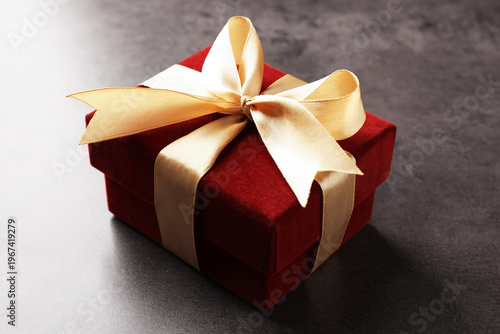 Red velvet gift box on grey table, closeup