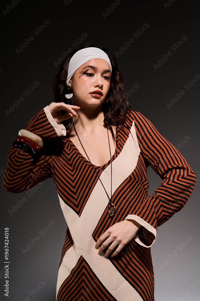 Obraz premium Stylish young woman showcases bold striped dress in modern studio setting