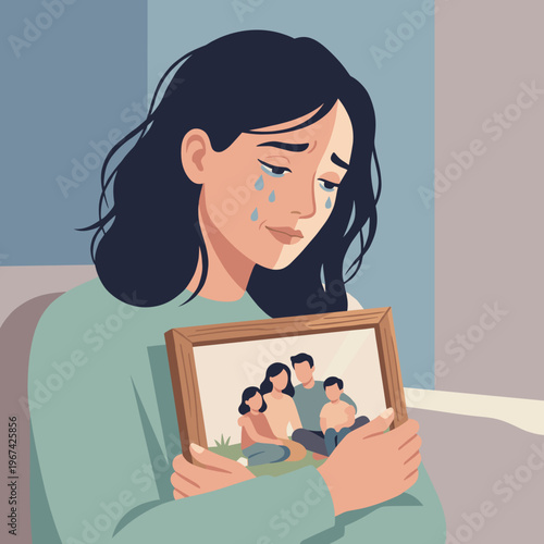 Woman crying while holding family photo indoors with soft light  