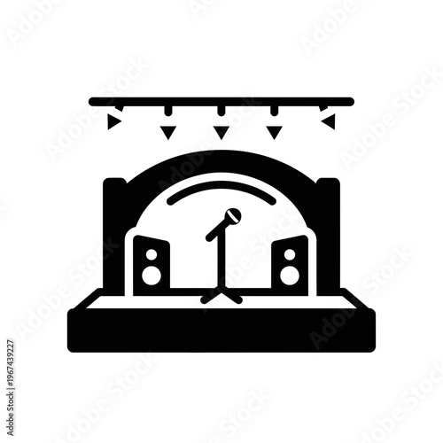 Concert stage with microphone and speakers under the lights.