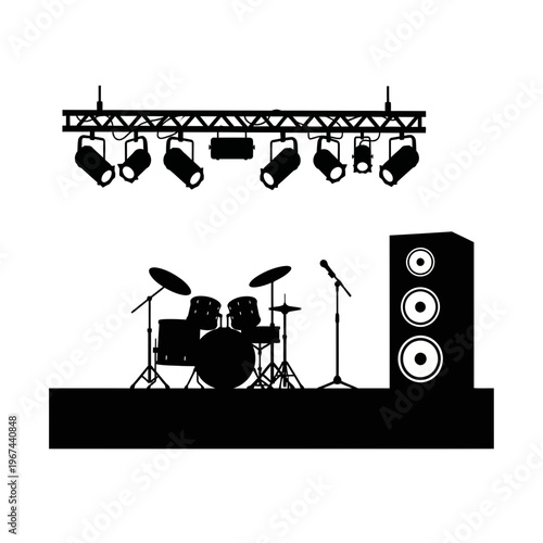 Silhouette of a stage setup with drums microphone and speakers under stage lights.