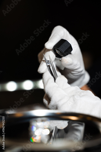 Obraz na plátně Gemologist inspecting diamond with tweezers and loupe to evaluate clarity and cut