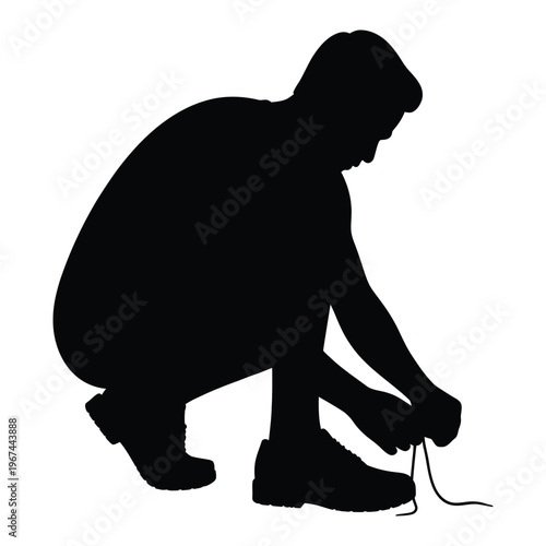 A man is crouching down tying his shoelaces in a stark black silhouette
