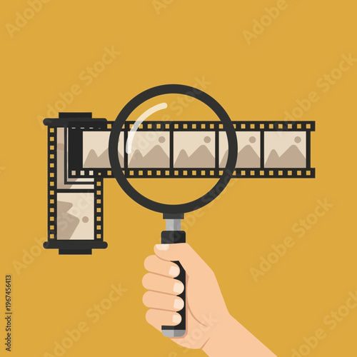 Magnifying glass examining film strip revealing images concept of analysis and review.