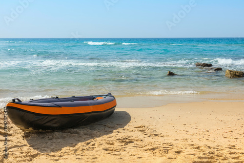 A rubber inflatable boat is docked on a sandy beach