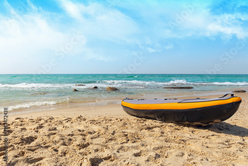 A rubber inflatable boat is docked on a sandy beach