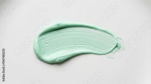 A mint green creamy cosmetic smear with a smooth glossy texture spread neatly on a clean white background in a minimal skincare style.