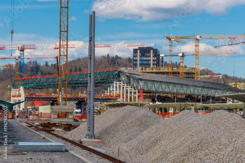 Construction of the new Emonika railway station in Ljubljana, Slovenia. Scaffolding and platforms rise at sunset as part of a major urban infrastructure project and transport hub upgrade.