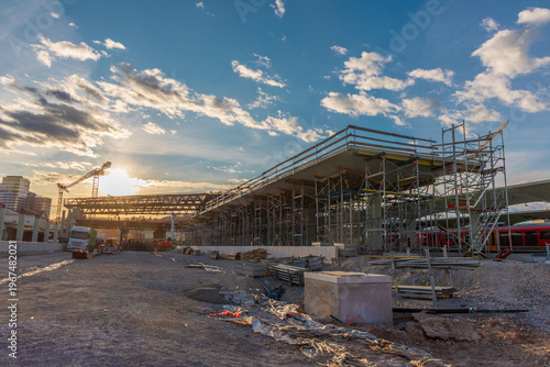 Construction of the new Emonika railway station in Ljubljana, Slovenia. Scaffolding and platforms rise at sunset as part of a major urban infrastructure project and transport hub upgrade.