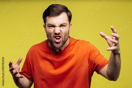 Obraz na płótnie Man with beard and orange t-shirt showing extreme anger, shouting, and expressin