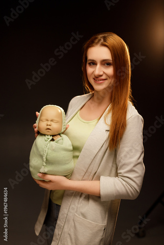 Woman practicing newborn photography with a baby doll