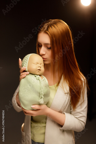 Young Woman Practicing Newborn Photography with a Baby Doll
