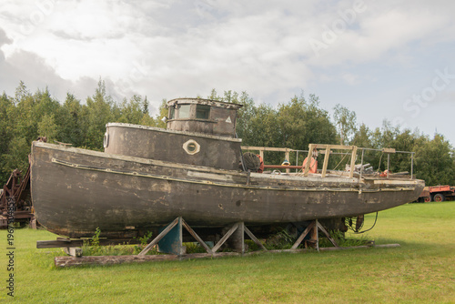 Old wooden boat put up on land 