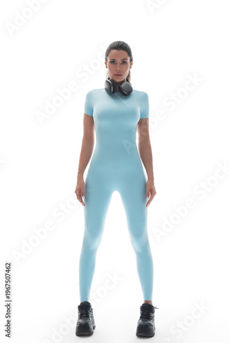 A beautiful girl in a sports suit posing on a white background