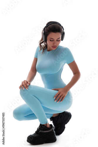 A beautiful girl in a sports suit posing on a white background