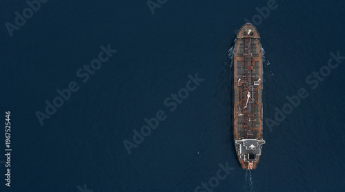 Aerial top view of oil tanker ship sailing on dark open sea