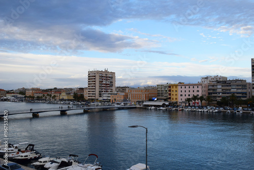 Zadar waterfront cityscape in Croatia with marina, bridge, and Adriatic sea view. European coastal town featuring buildings, boats, and calm harbor water reflections. Scenic urban landscape with sea