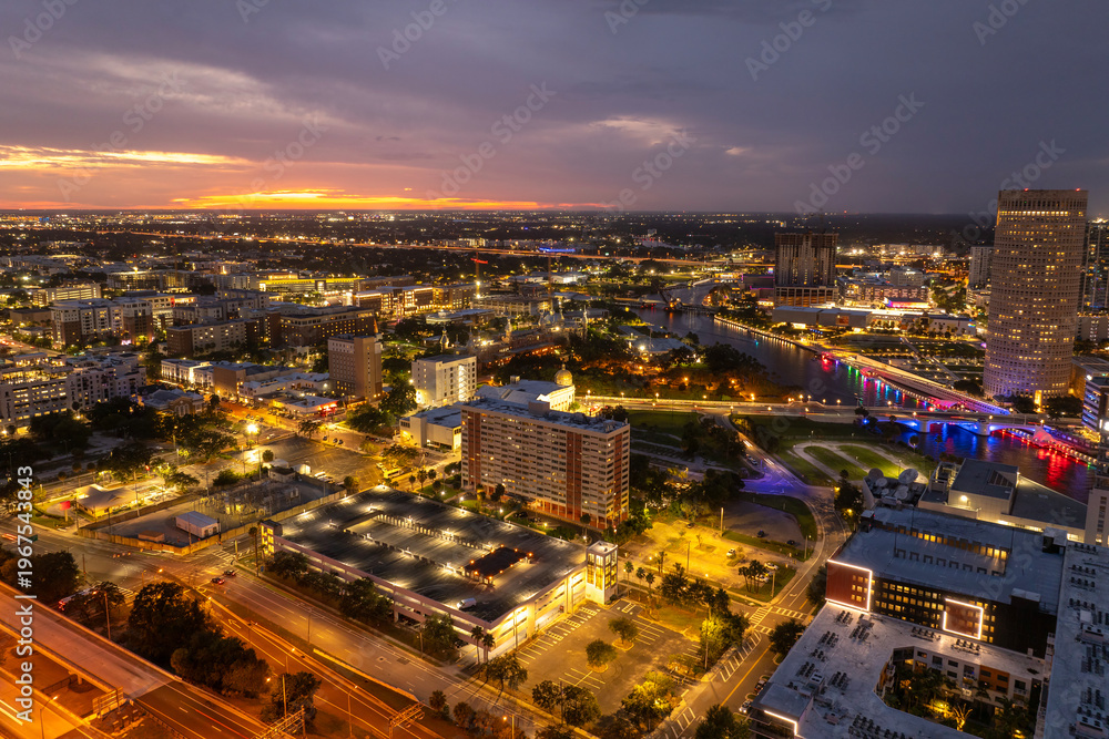 Fototapeta premium Tampa, Florida. Downtown district of American city after sunset with brightly illuminated high buildings and street traffic. USA travel destination.