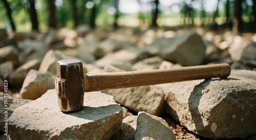 Heavy mallet resting on large rocks in a sunlit forest