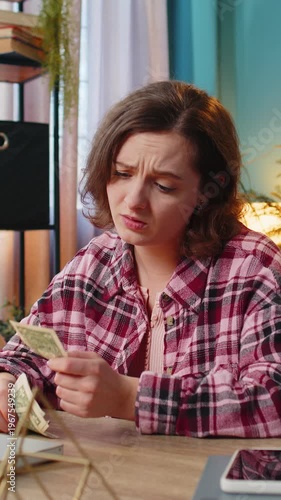 Caucasian young woman freelancer counting cash insufficient amount of money. Financial crisis. Bankruptcy. Poverty and destitution. Female girl businesswoman with laptop sitting at home office table.