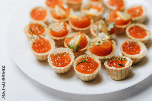 Exquisite canapes with salmon roe and dill adorn a white plate, perfect for gourmet events and culinary presentations.