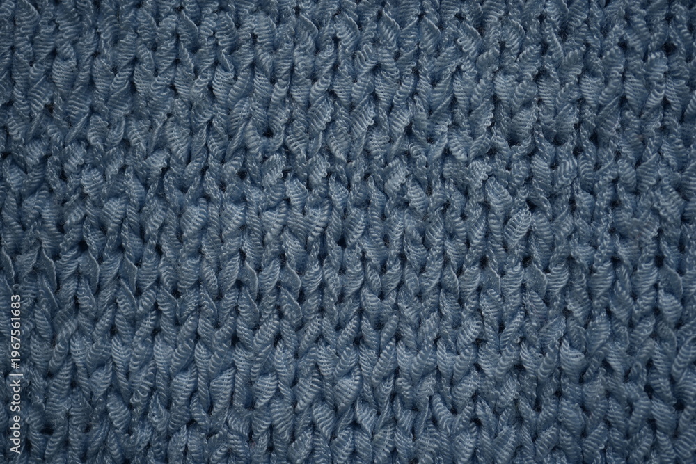 Fototapeta premium macro texture of blue knitted fabric with detailed pattern. Close-up of soft textile showing woven structure and calm cool tones. Clean and modern background perfect for winter concepts, fashion, tech