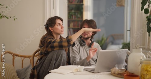 Two friends exchange ideas using a laptop in a cozy, green-filled space
