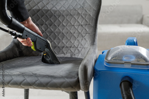 Upholstery cleaning chair with extractor vacuum removing dirt from fabric seat