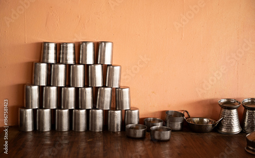 stack of metal drinking glasses and utensils on a table, indian kitchen